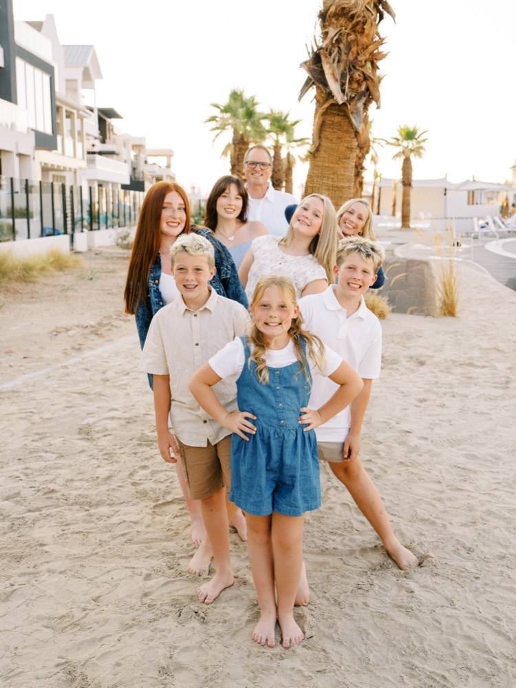 Becky and Jake with their six kids on the beach